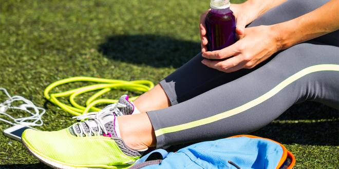 A runner taking a break to drink her beetroot juice