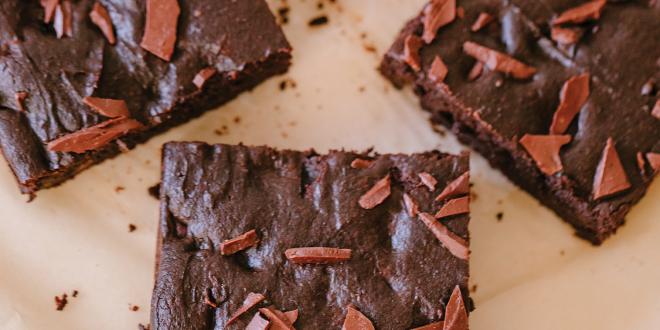 freshly baked brownies cut into squares on parchment paper.