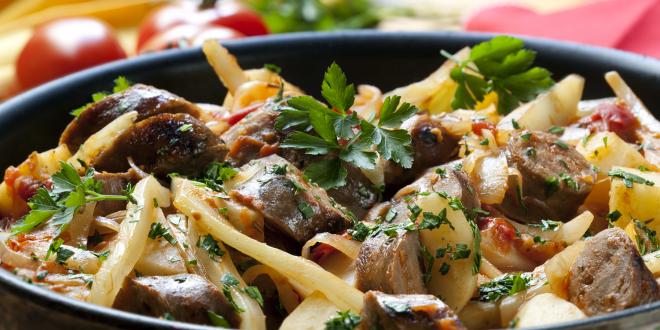 a dish of casserole with sausage, noodles, and green veggies