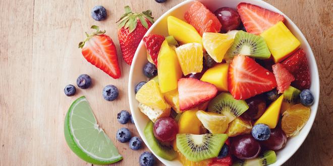 a bowl of fruit salad and a sliced lime