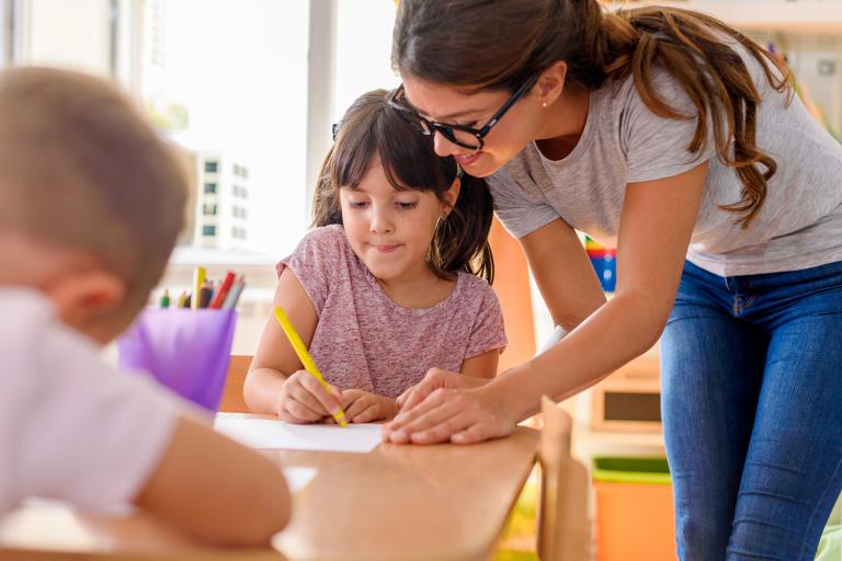 a girl getting help from her teacher in class